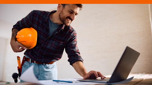 A builder working on a laptop computer
